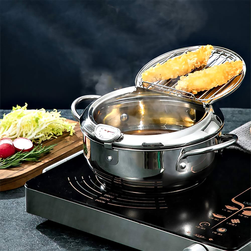 Stainless steel cookware for deep frying on electric stove with lid, fried food inside, and vegetables arranged on the side.