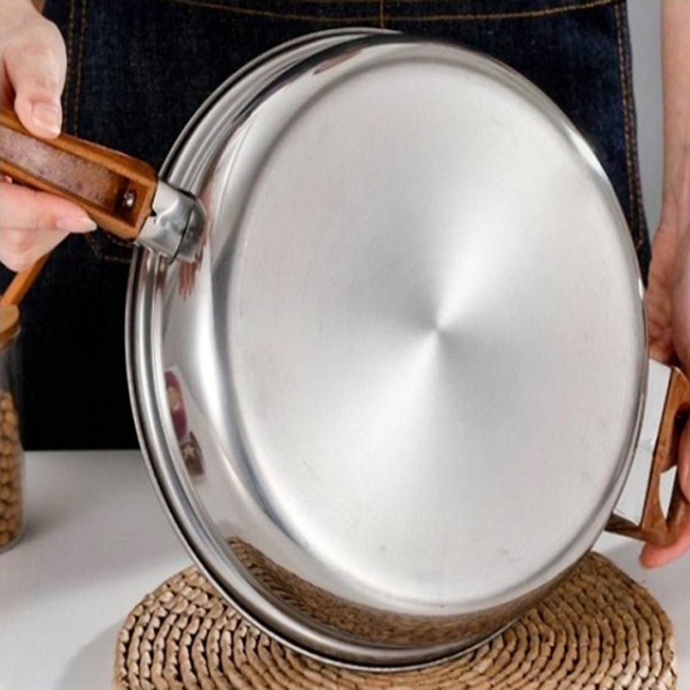 Woman holding a fry pan from cookware sets stainless steel, showcasing its sleek design and comfortable handle.