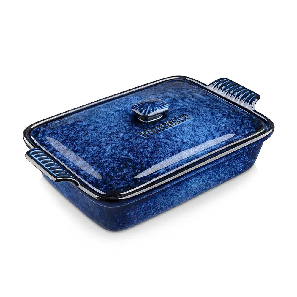 Blue porcelain covered rectangular casserole dish with matching lid and side handles placed on a white background.