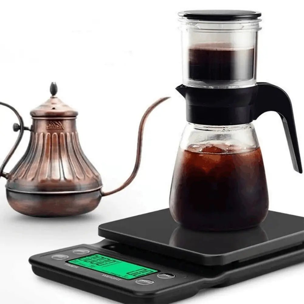 Digital kitchen scale with a glass coffee carafe on a white background.
