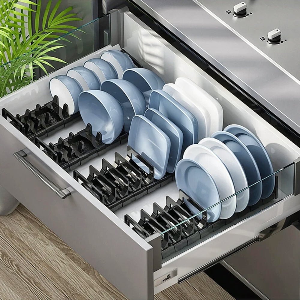 Four dish organizer cabinets in a kitchen drawer, holding various plates and bowls neatly in place.