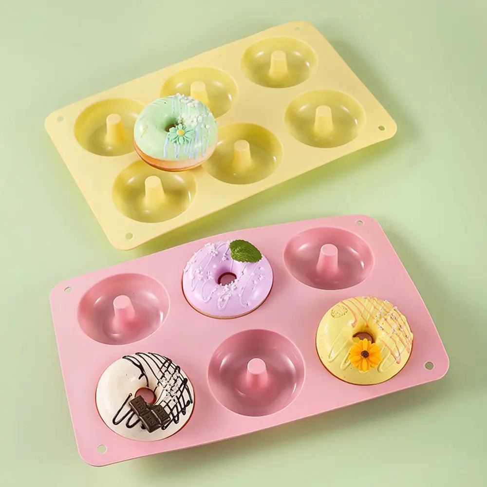 Two silicone doughnut pans on a light green background.