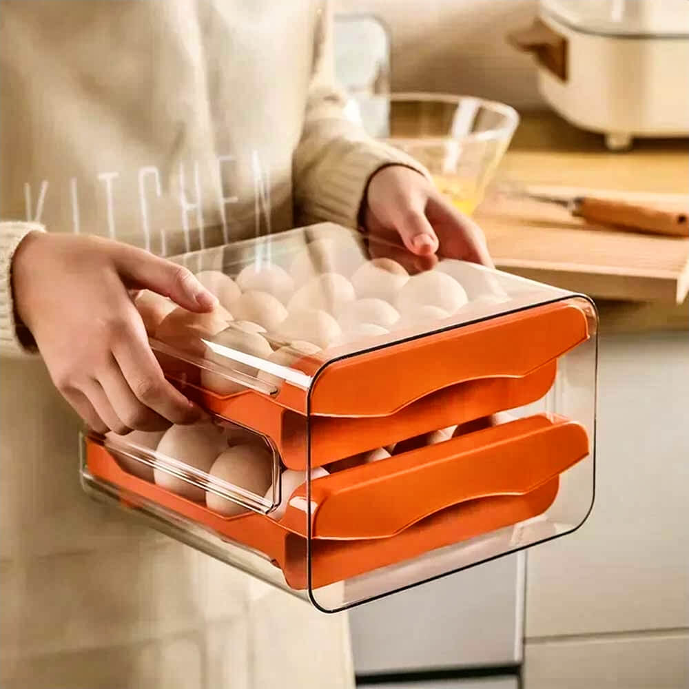 Person holding orange egg keeper for refrigerator with two drawers filled with eggs for organized, compact fridge storage.