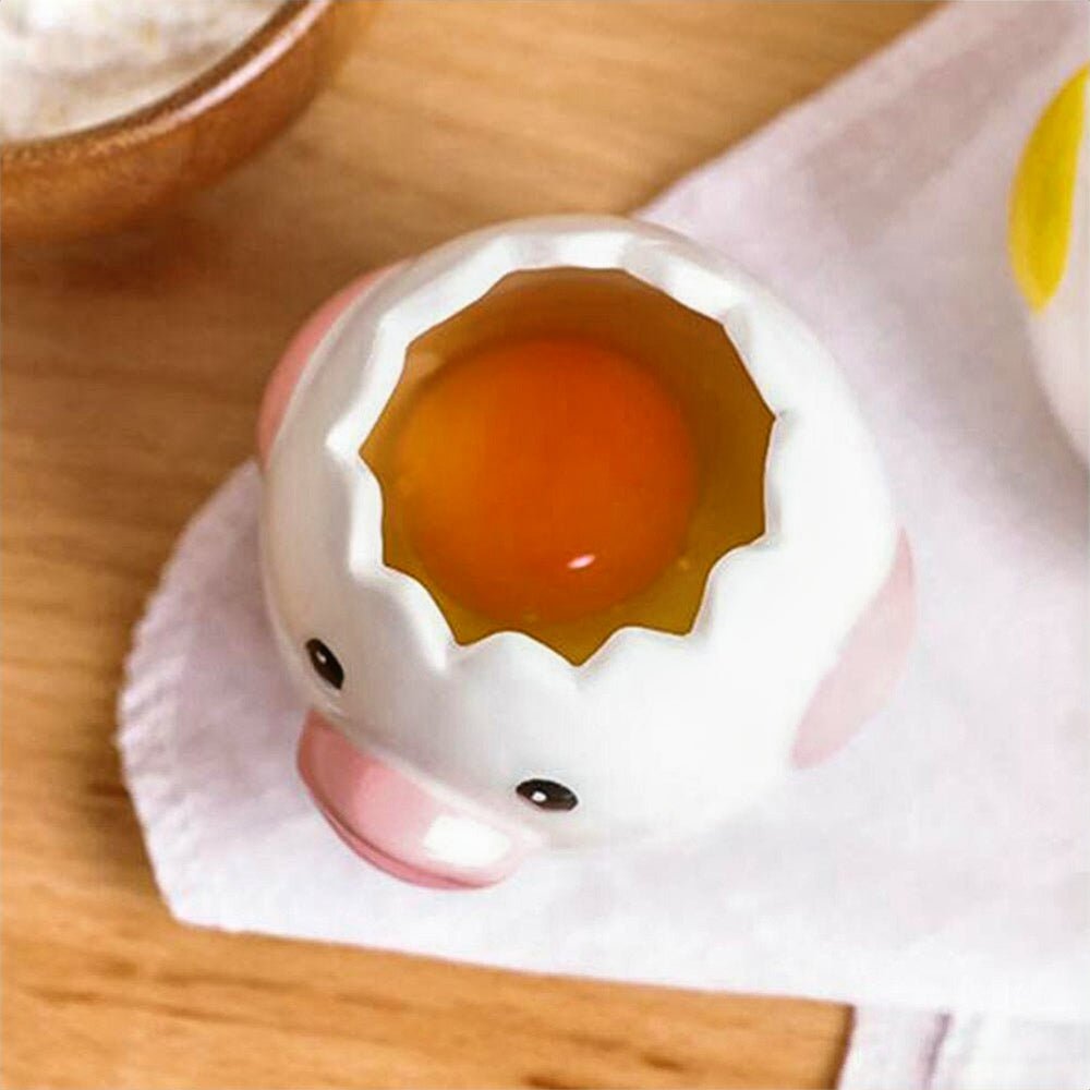 Egg separator in pink, holding a yolk and egg white, ready for easy separation, featuring a fun chick-inspired design.