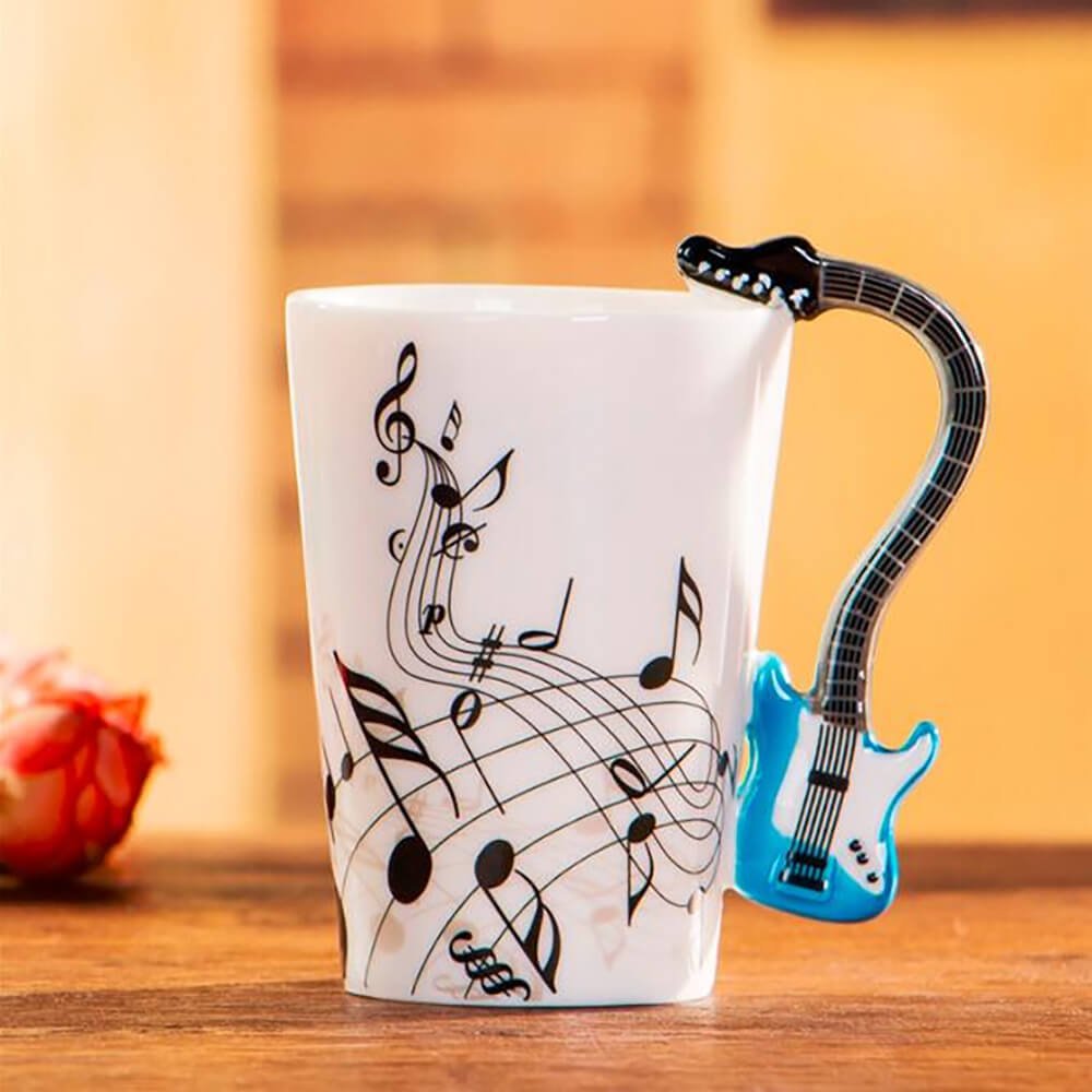 White electric guitar mug featuring black musical notes and a blue guitar-shaped handle, perfect for music lovers and collectors.