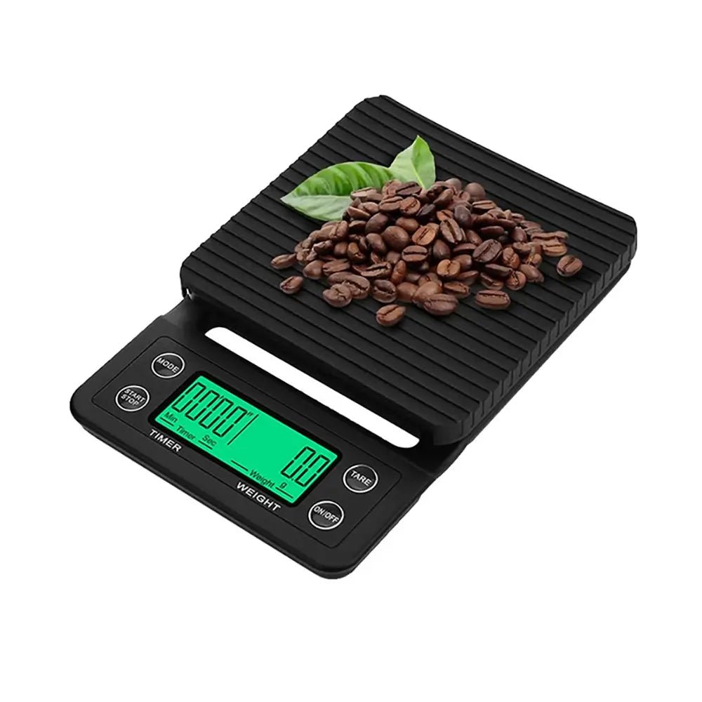 Digital kitchen scale with coffee beans and leaves on a white background.