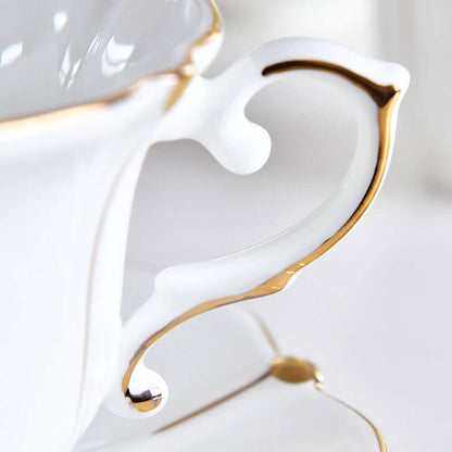 Close-up of a delicate handle with gold accents from an English tea set, showcasing intricate craftsmanship and elegant porcelain design.