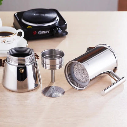 Disassembled stainless steel stovetop espresso maker with boiler, funnel, filter plate, and coffee container on a table.