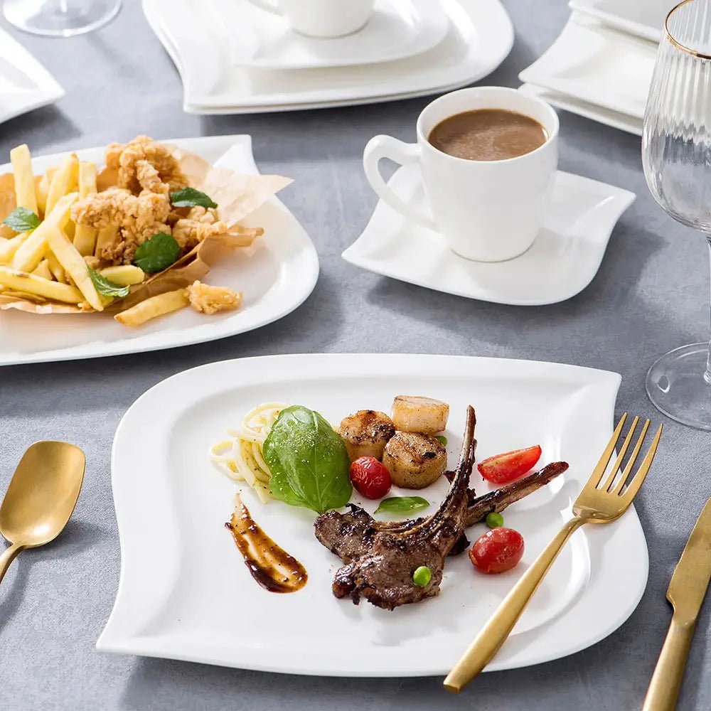 White everyday porcelain dinnerware sets with curved plates, cups, and saucers, served with lamb, fries, and coffee.
