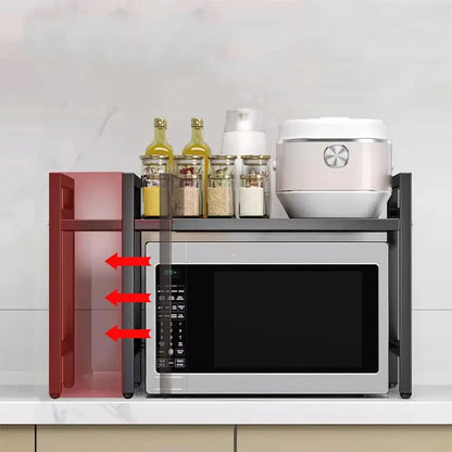 Expandable over microwave shelf with adjustable width, holding spice jars and rice cooker above a silver microwave.