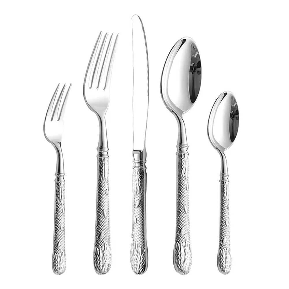 A five-piece flatware collection arranged in a row, including a dinner fork, salad fork, knife, tablespoon, and teaspoon. Each piece has a shiny, polished stainless steel finish with detailed embossed patterns on the handles, featuring leaf and grain designs.