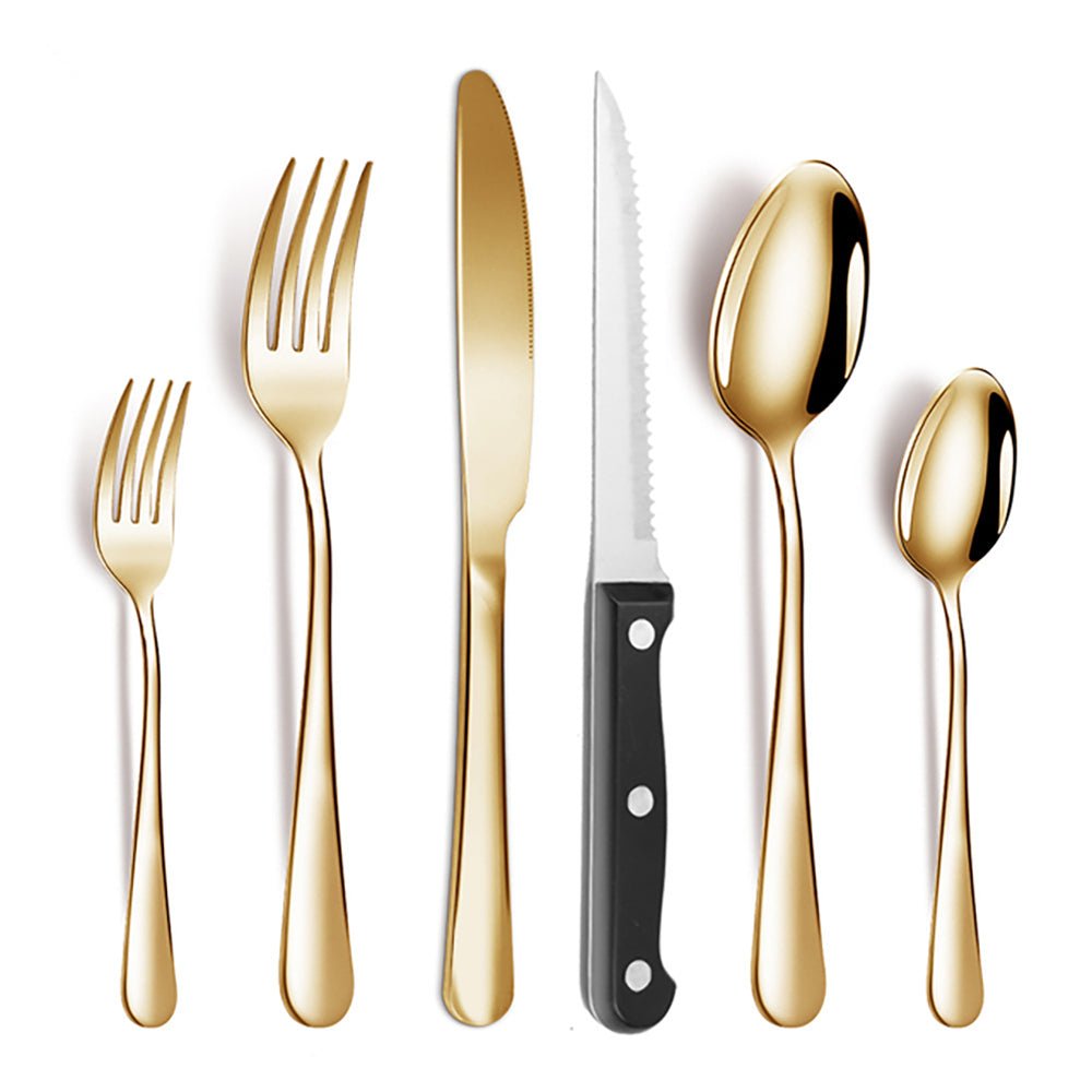 Gold stainless steel flatware set with forks, spoons, table knife, and serrated steak knife with black handle on white background