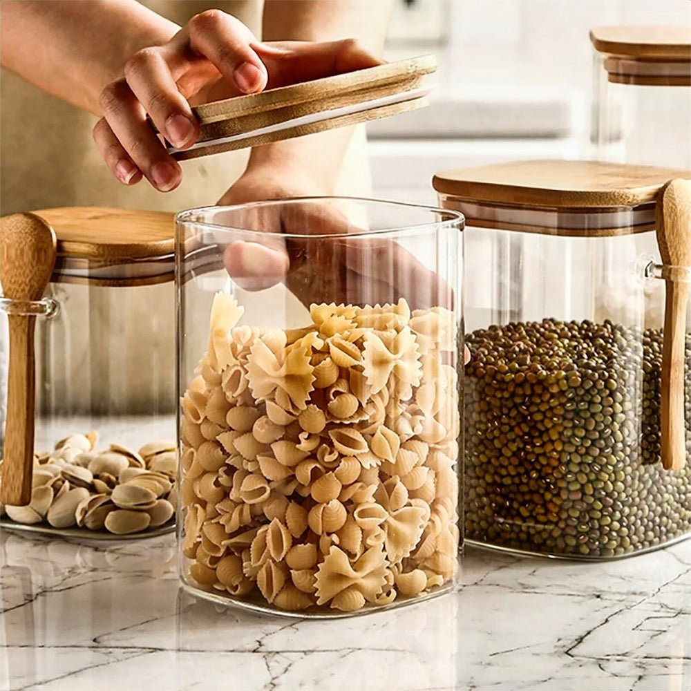 Canisters for flour, sugar, coffee, and tea storage, crafted from glass with bamboo lids.