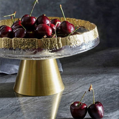 An elegant footed-fruit-bowl-centerpiece crafted from high-quality glass features a textured gold rim that adds a luxurious touch. The sturdy brass-tone base provides stability and modern charm, perfect for showcasing vibrant fruits like cherries or serving as a sophisticated table centerpiece.