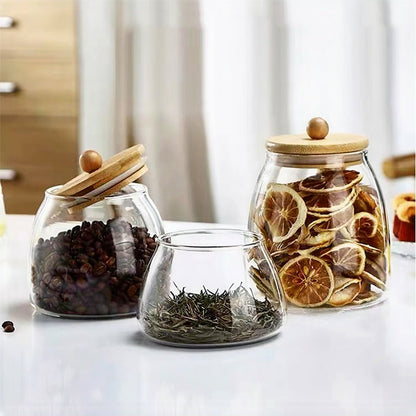 Three elegant glass and bamboo jars, featuring airtight lids for stylish kitchen storage solutions.