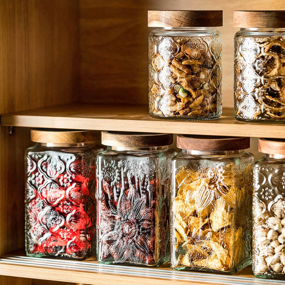 Airtight glass canister sets with acacia wood lids for preserving kitchen freshness.