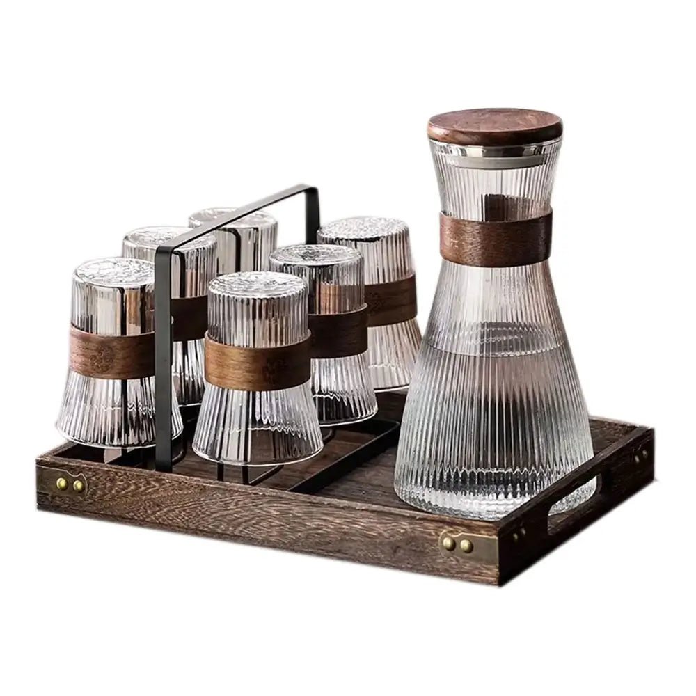 Glass pitcher and glasses set with ribbed design, wooden accents, and wooden tray holder placed on a table.