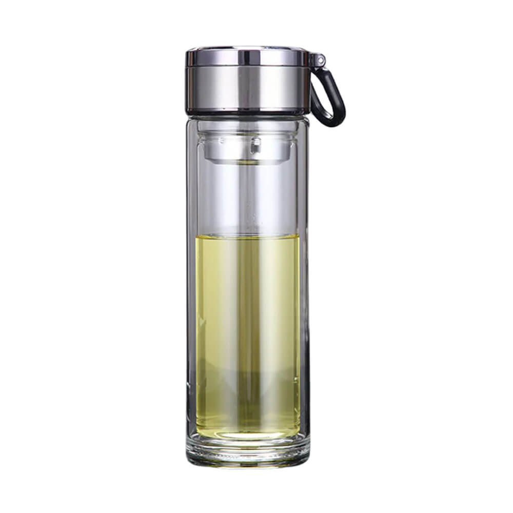 A sleek, transparent glass travel tumbler with a stainless steel lid and a black carrying loop. The tumbler is filled halfway with a light yellow liquid, and features a double-walled design for insulation.