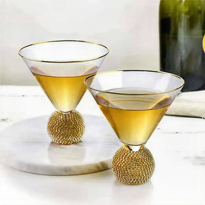 Two gold rimmed wine glasses elegantly placed on a table, adding a touch of luxury to the setting.