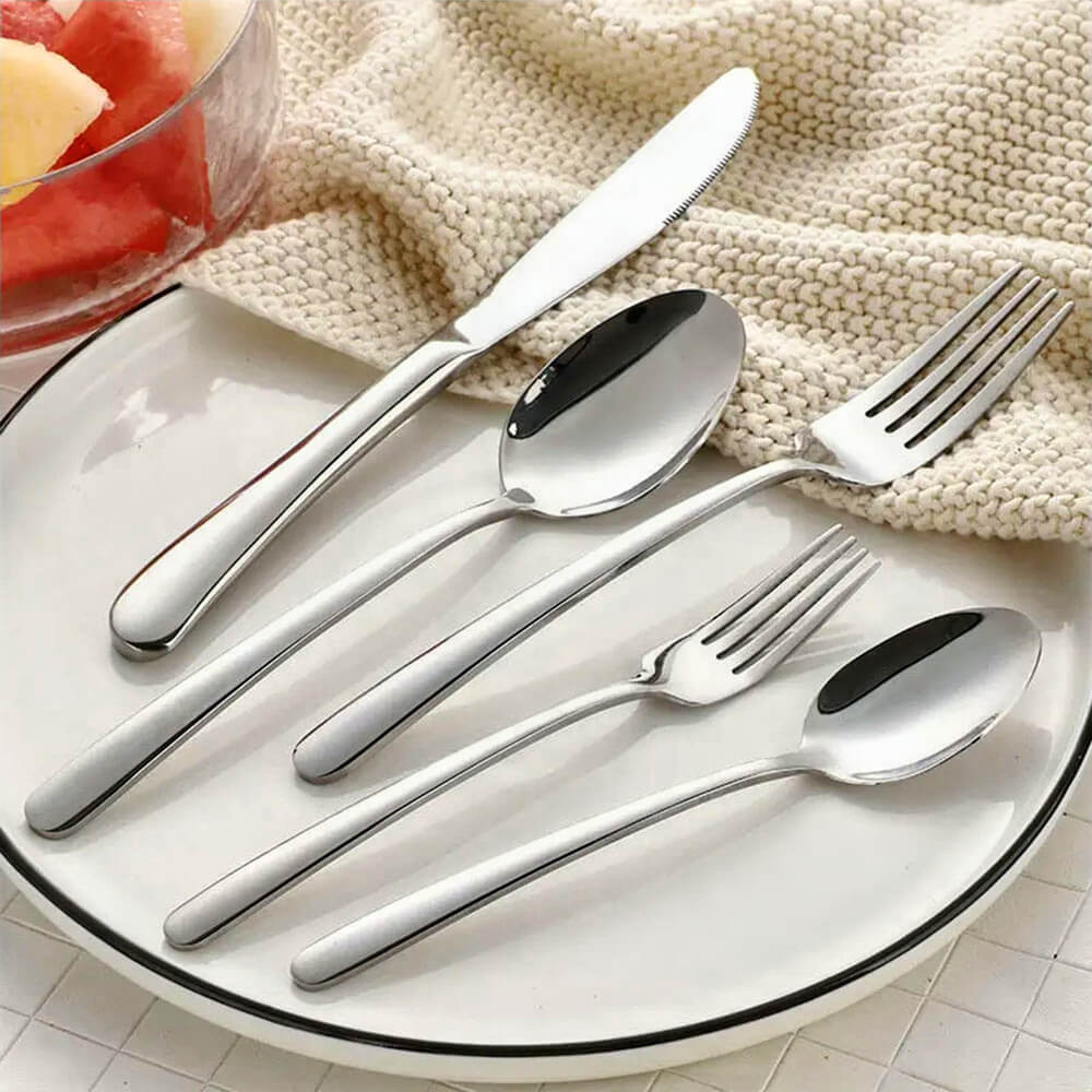 A clean and refined arrangement of a good silverware set, featuring a knife, forks, and spoons crafted with sleek stainless steel. The utensils lie on a classic white plate with a thin black rim, paired with a cozy cream knit cloth for an inviting and elegant dining display. A bowl of fresh fruit adds a vibrant touch to the scene, enhancing the appeal of this versatile silverware set for everyday meals or special occasions.