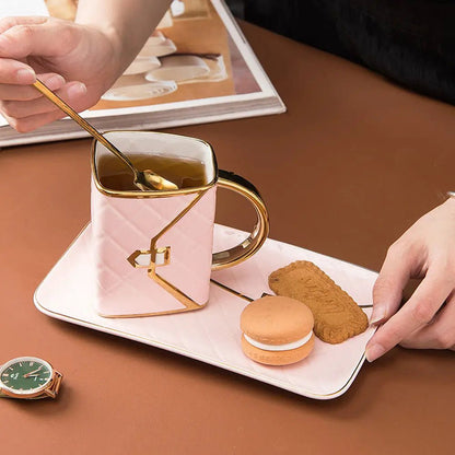 Person holding a spoon over a pink mug with gold handle on a tray with cookies and macarons.