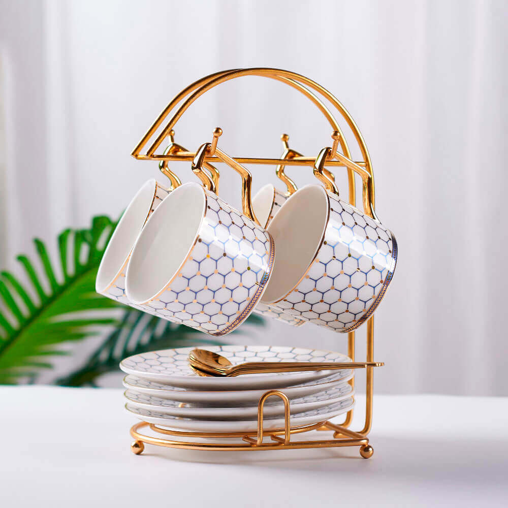 Elegant honeycomb tea cup set featuring intricately designed cups and saucers with a matching gold rack, perfect for a stylish tea experience.