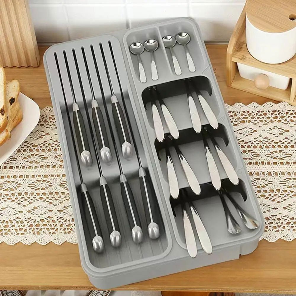 Grey plastic in-drawer organizer with compartments for cutlery and knives.