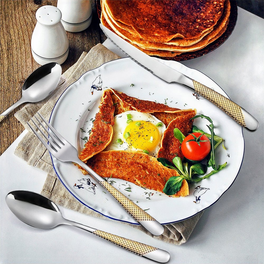 Modern flatware sets displayed next to a plate with an omelette.