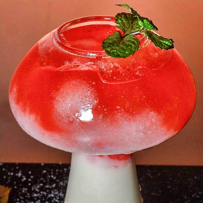 Vibrant mushroom cocktail glass featuring a bold red beverage with frosted detailing, elegantly designed to resemble the shape of a mushroom. The wide, rounded top transitions into a smooth, narrow stem, creating a unique and eye-catching design. Garnished with a fresh mint sprig, this mushroom cocktail glass is perfect for serving signature drinks with style.