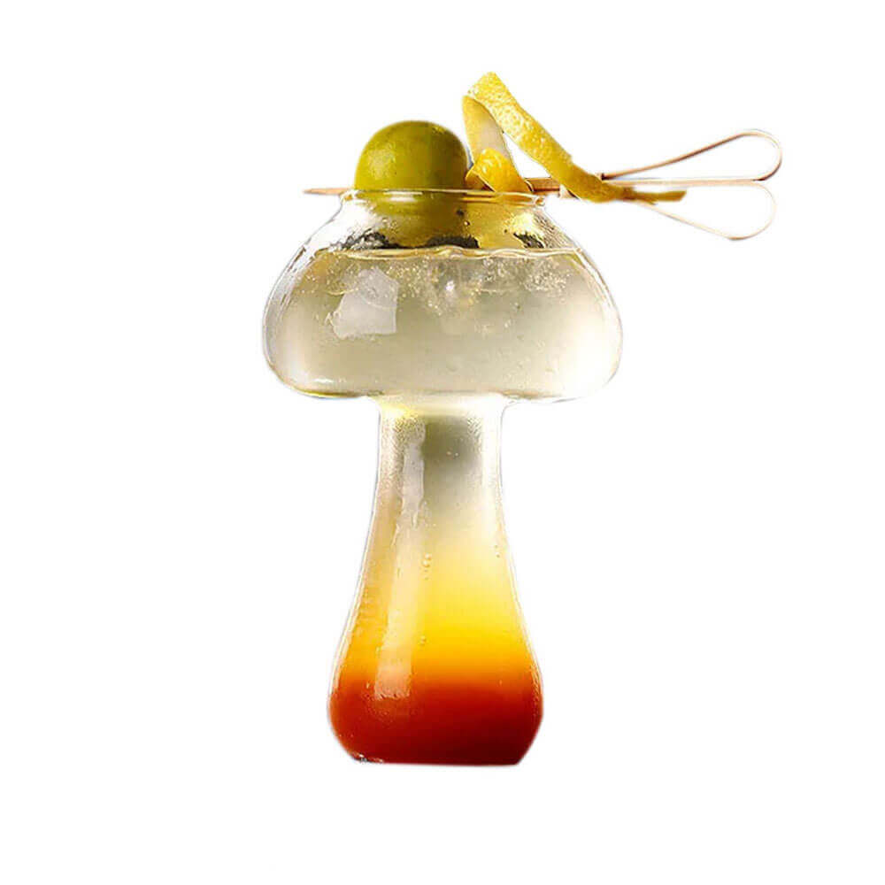 Elegant mushroom glassware shaped like a whimsical mushroom, featuring a unique gradient design with a warm orange base transitioning into clear glass at the top. The glass is filled with a refreshing cocktail and garnished with an olive and a lemon twist, adding a sophisticated touch to this artistic drinkware.