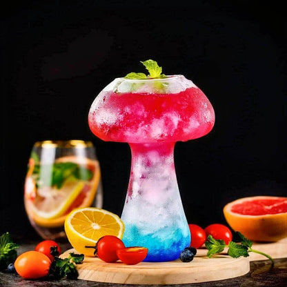 Vibrant mushroom shaped glass featuring a colorful gradient design that transitions from a deep blue base to a bright pink top. The frosted texture enhances its whimsical appearance, while the rounded mushroom cap holds a refreshing beverage garnished with a fresh mint leaf. Perfect for creative cocktail presentations, this mushroom shaped glass adds a playful and artistic touch to any drink.