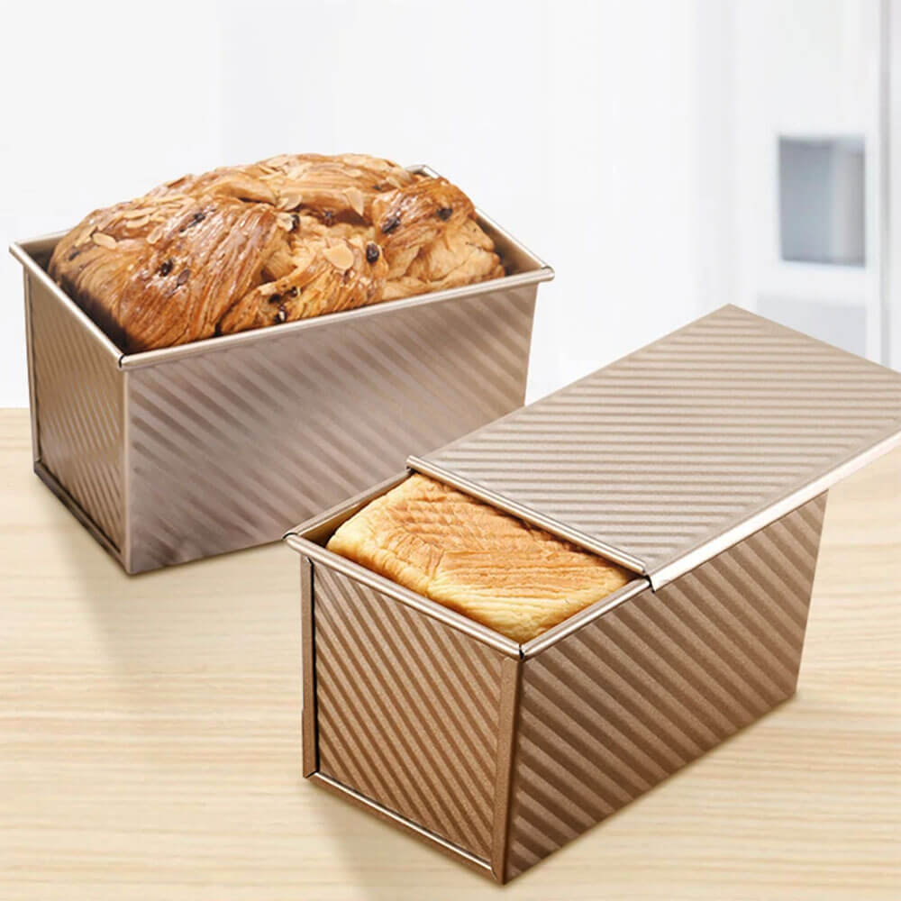 A pair of non stick bread loaf pans made of carbon steel with a textured surface, ensuring even heat distribution and easy release. These non stick bread loaf pans are perfect for baking fluffy, golden loaves and are ideal for any baking enthusiast.