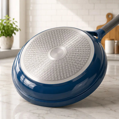 Bottom view of a blue non stick ceramic cookware set skillet showing the induction-compatible base and ergonomic handle.