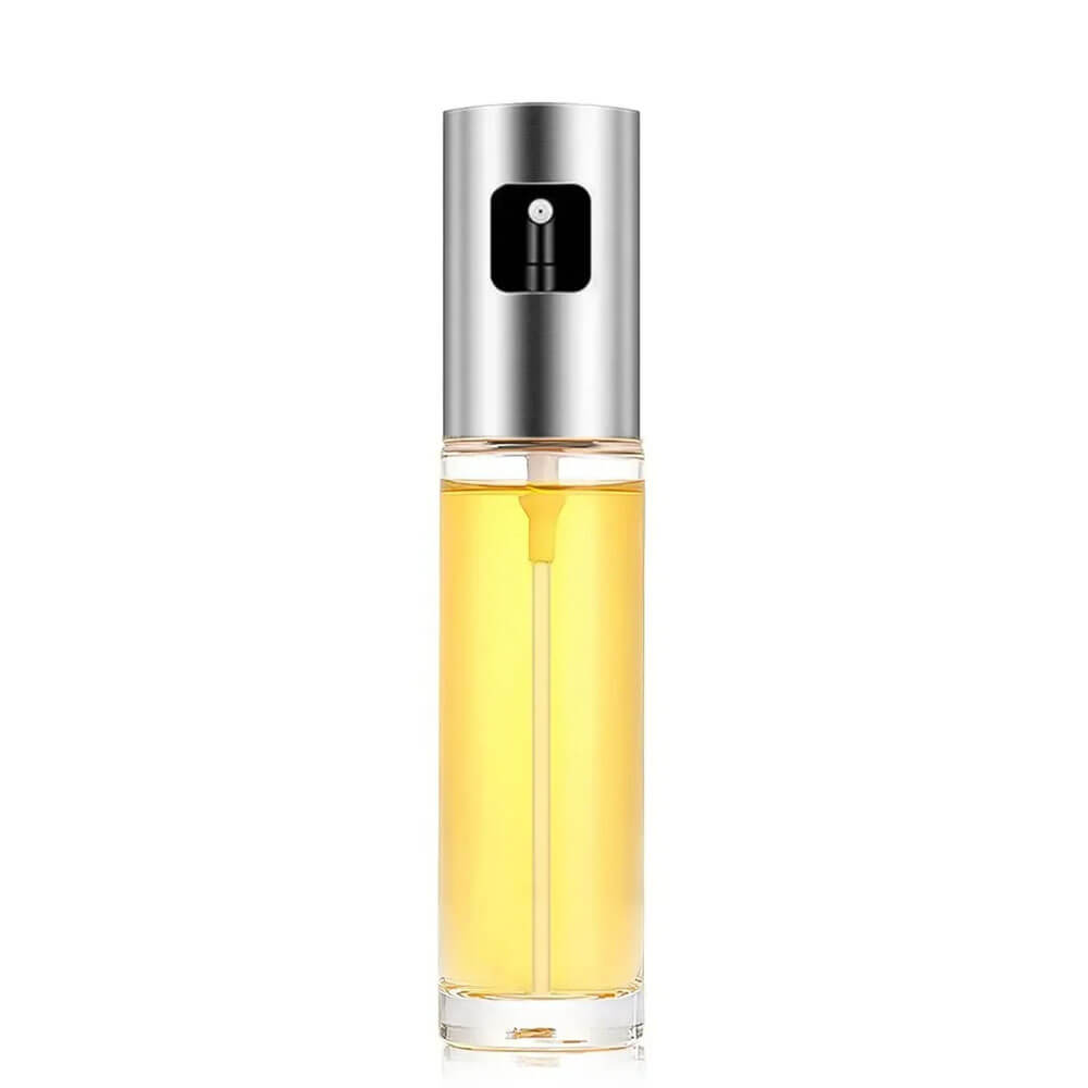 A transparent oil spray bottle with a sleek stainless steel top and a precision spray nozzle, filled with golden oil, set against a plain white background.