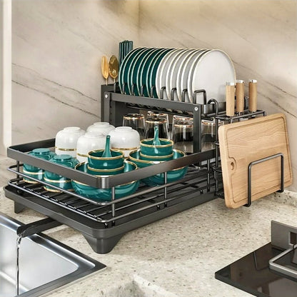 An over-the-sink dish drying rack holding plates, bowls, cutlery, and cutting boards, maximizing space.