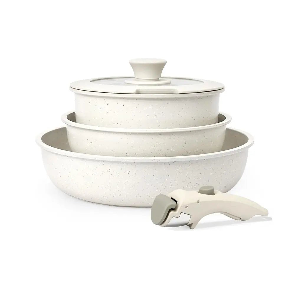 Pans with removable handles stacked together with a glass lid on top and the detachable handle placed in front on a white background.