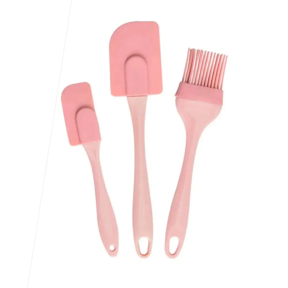 Pink silicone kitchen utensil set with two spatulas and a pastry brush displayed on a white background.