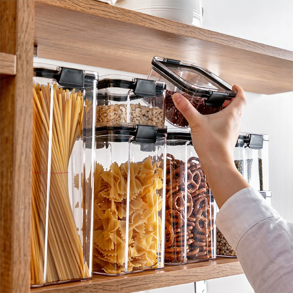 Woman organizing a set of plastic canisters for flour and sugar, arranging pantry essentials neatly.