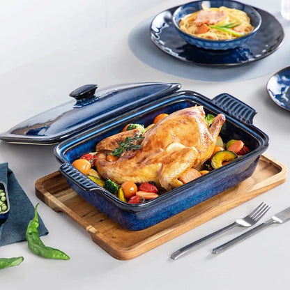 Blue porcelain casserole dish filled with roasted chicken and vegetables, placed on a wooden board with its matching lid beside it.