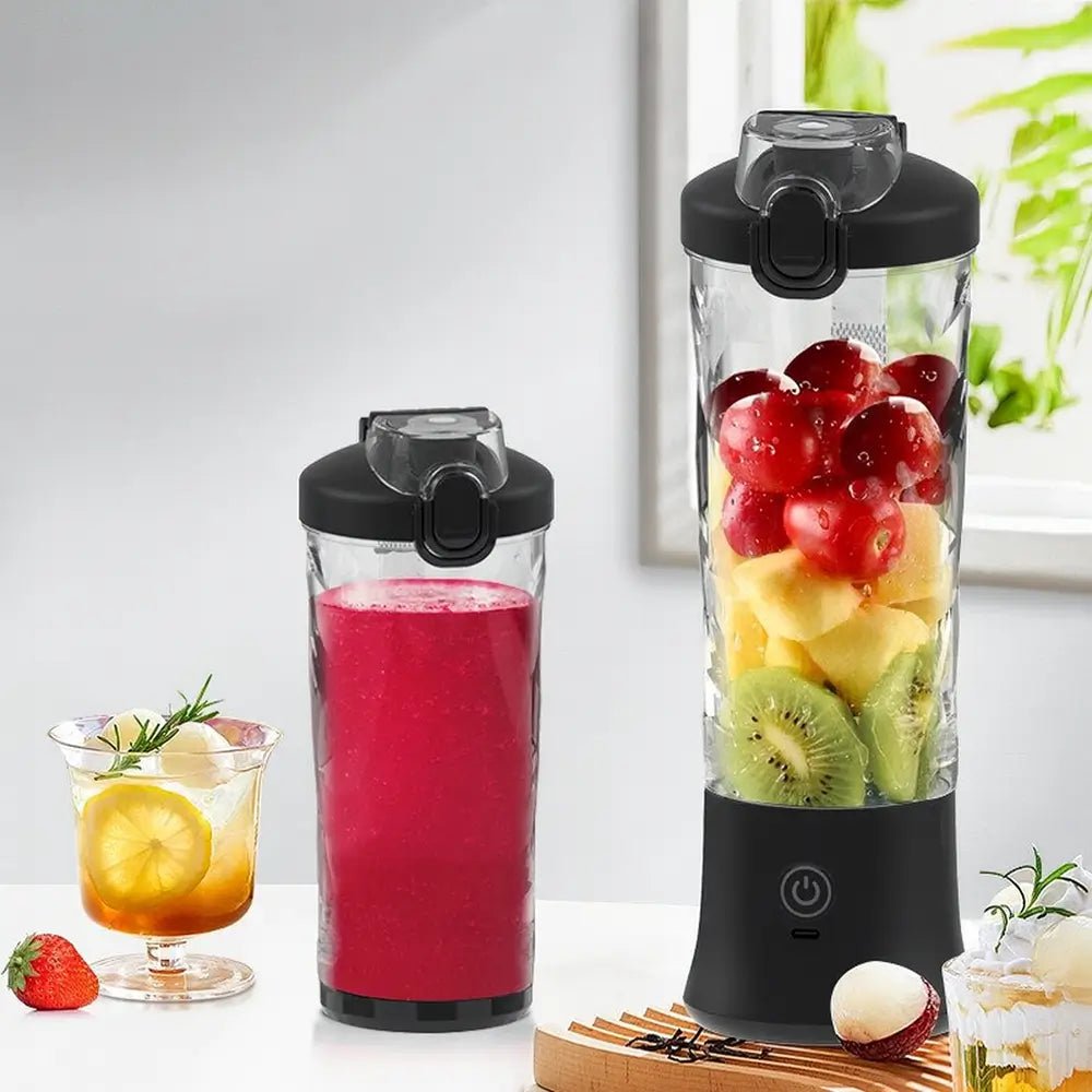 portable blender with black lid filled with fruit beside another blender cup with red smoothie on white table.