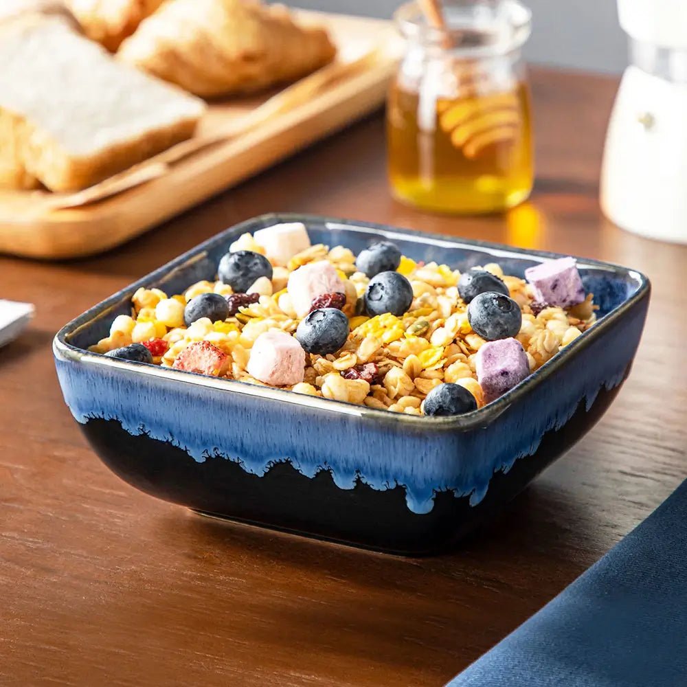 Blue ceramic bowl filled with cereal and blueberries on a wooden table.