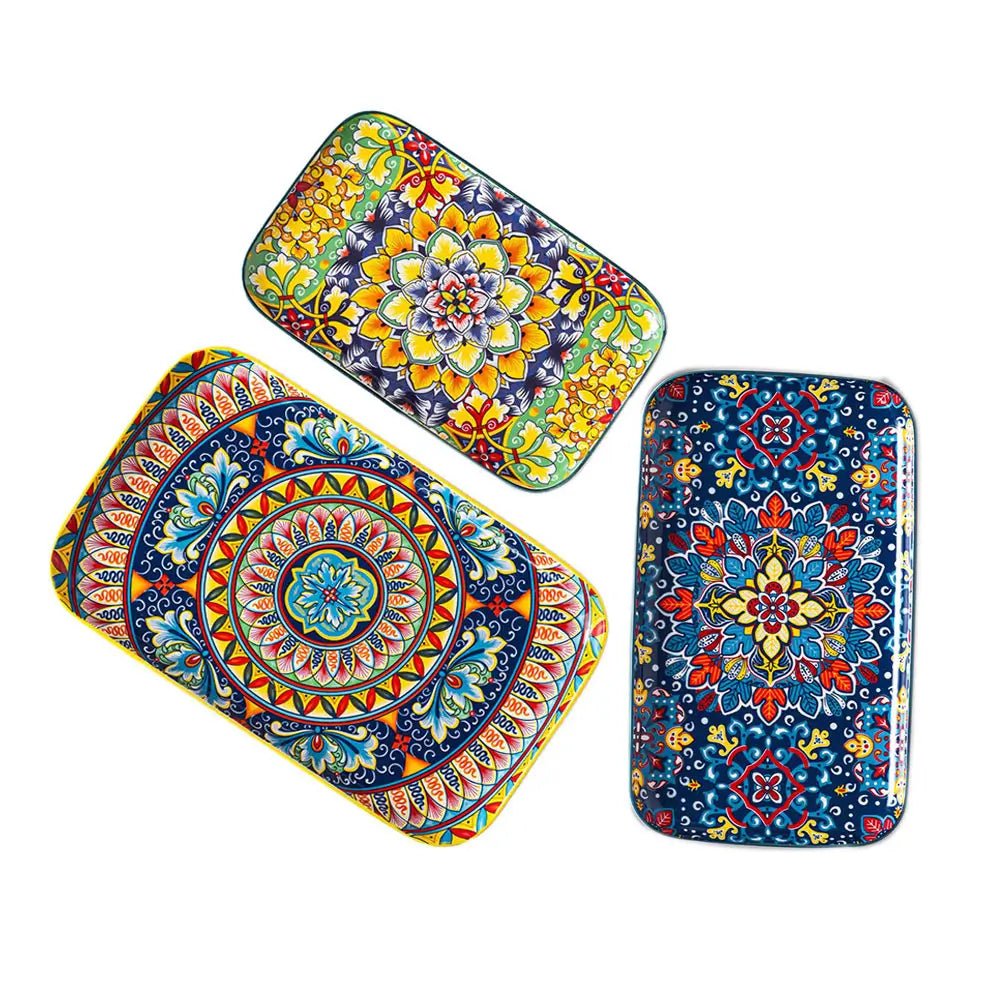 Three rectangular serving plates set with colorful floral and geometric patterns on a white background.