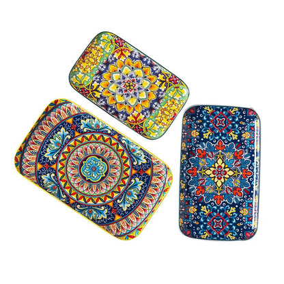 Three rectangular serving plates set with colorful floral and geometric patterns on a white background.