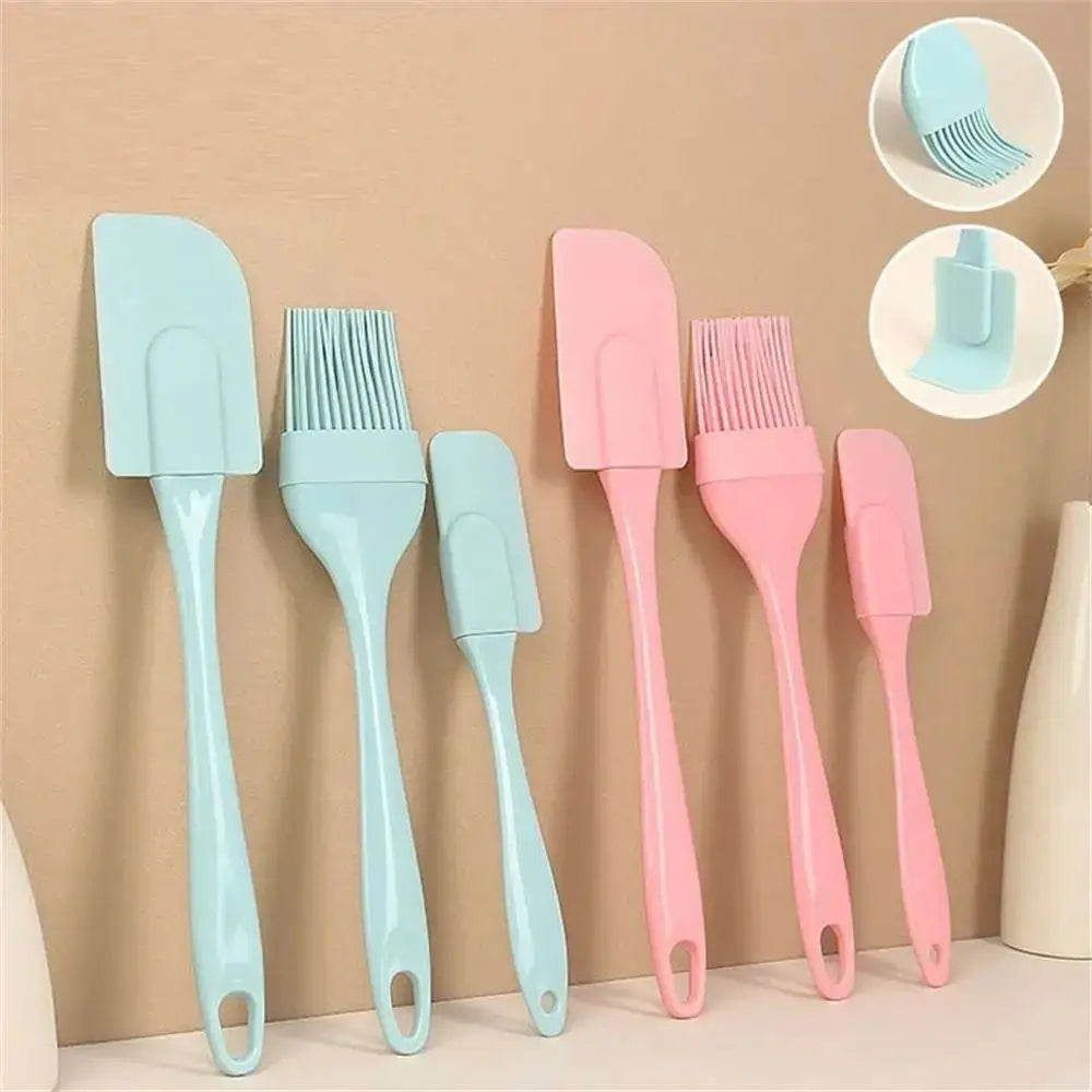 Silicone kitchen cooking utensil set with spatulas and pastry brushes in blue and pink displayed on a countertop.