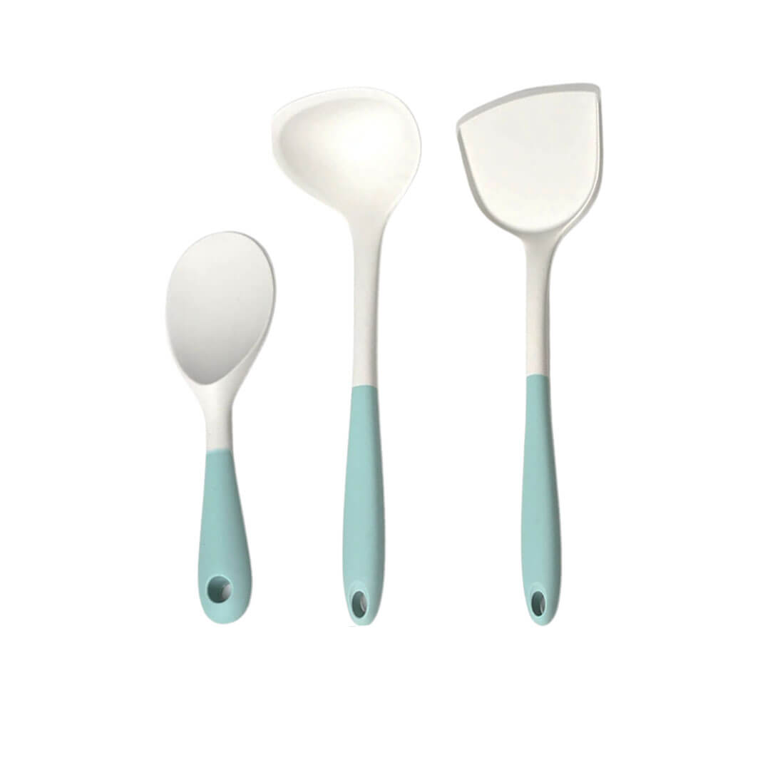 A silicone kitchen utensil set consisting of three essential tools: a serving spoon, a ladle, and a spatula. Each utensil features a white silicone head and a pastel green ergonomic handle with a hanging hole for easy storage. The set is designed for non-stick cookware, offering durability and a modern kitchen aesthetic.