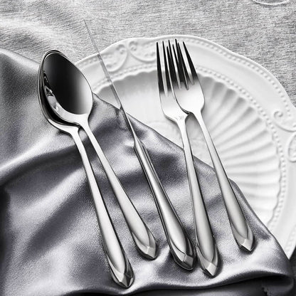 A silverware set made from 18/10 stainless steel, featuring a polished mirror finish, displayed on a silver fabric with a white decorative plate in the background. The set includes a spoon, fork, and knife with sleek, tapered handles.