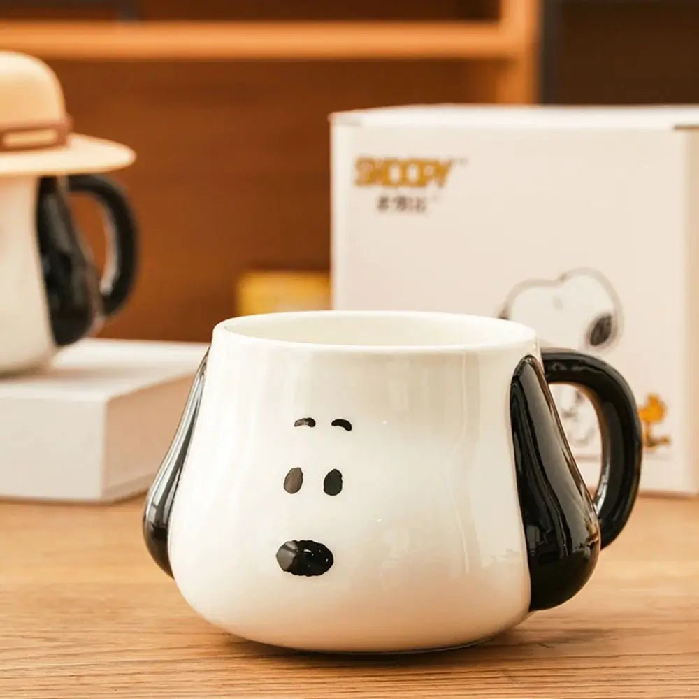 White Soopy mug with a black handle and face design on a wooden surface.