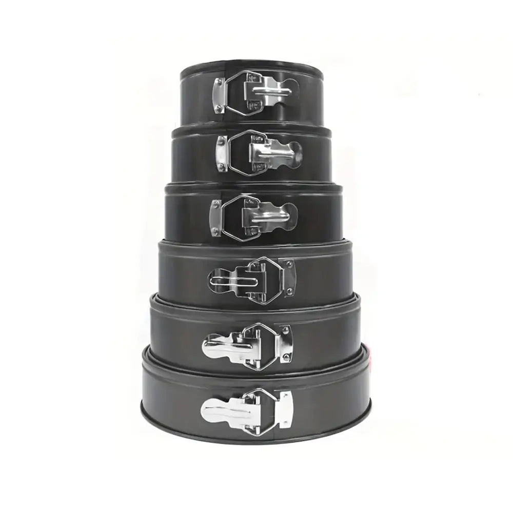 Set of five black metal springform cake pans with silver handles on a white background.