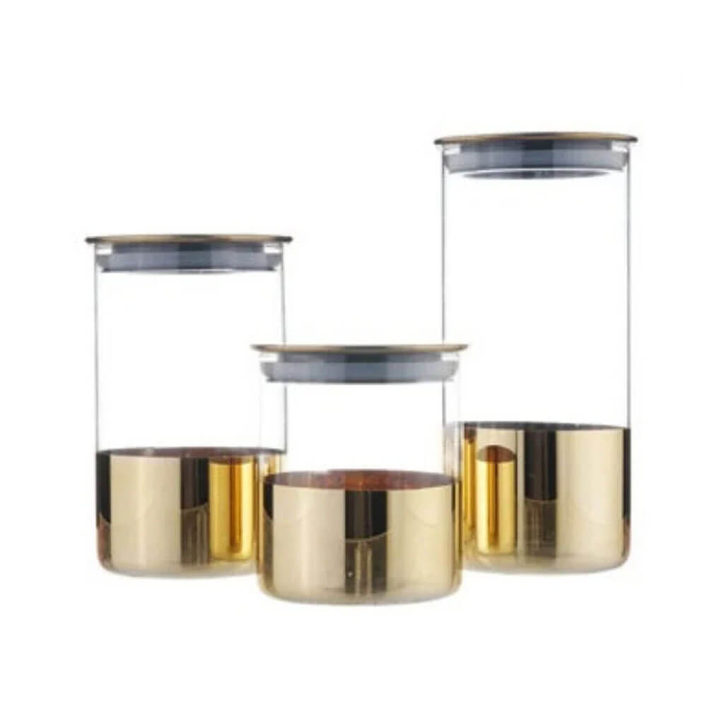 A set of three stackable glass canisters with gold metallic bases and airtight lids is displayed against a plain white background. The canisters vary in height, offering versatile storage options for kitchen essentials.