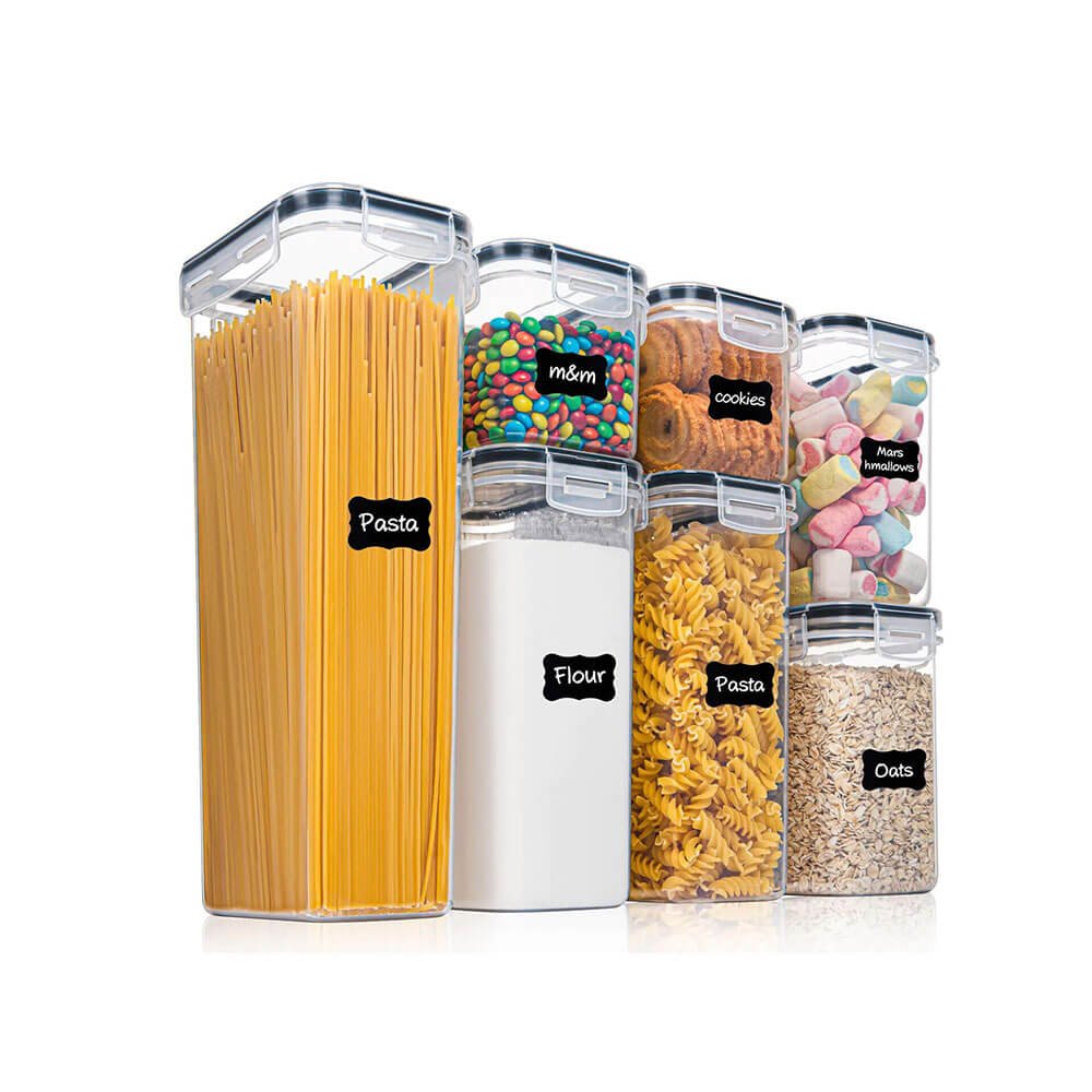 Stackable pantry containers filled with pasta, flour, oats, cookies, and candies for organized kitchen storage.